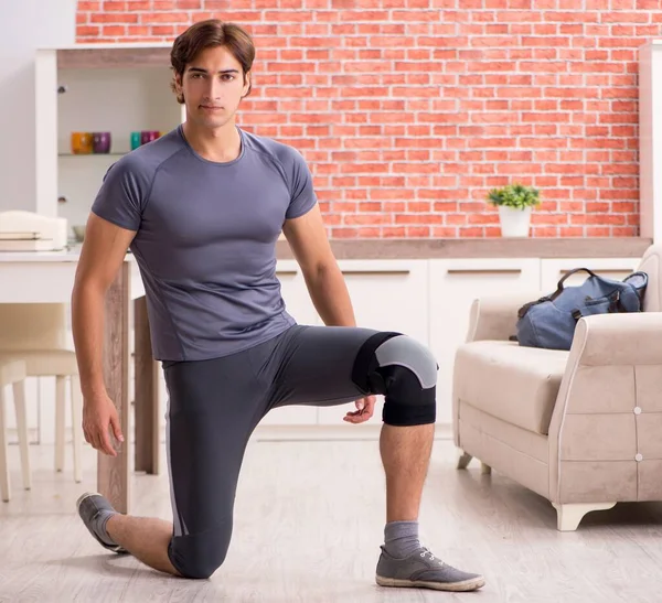 Genç yakışıklı adam evde spor egzersizleri yapıyor.