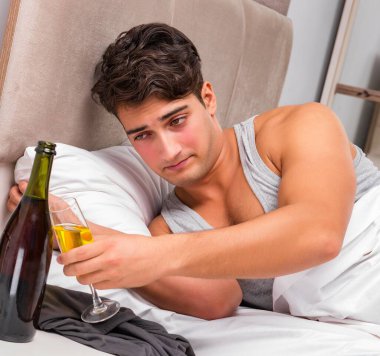 Partiden sonra yatakta yatan adam, akşamdan kalma konsepti.