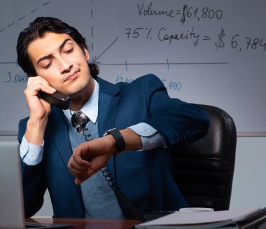 Ofiste geç saatlere kadar çalışan finans uzmanı.