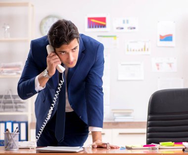 Genç yakışıklı satış elemanı ofiste çalışıyor.