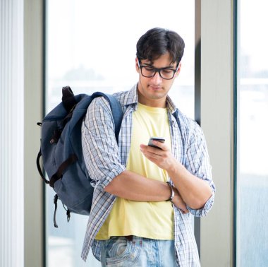 Pencerenin önünde duran genç ve yakışıklı öğrenci.