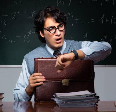 Tahtanın önündeki genç matematik öğretmeni.