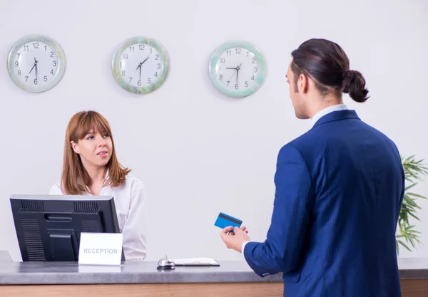 Stock image The young businessman at hotel reception