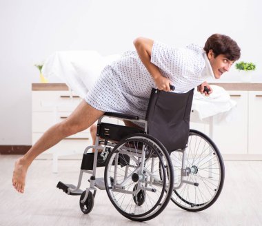 Hastanedeki tekerlekli sandalyedeki genç adam.