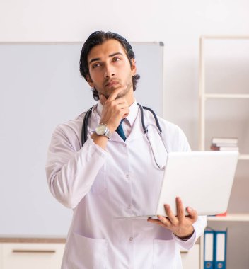 Beyaz tahtanın önündeki genç doktor.