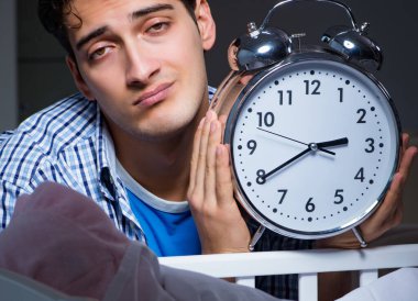 Yeni doğan bebeğe bakarken uyuyan genç baba baba