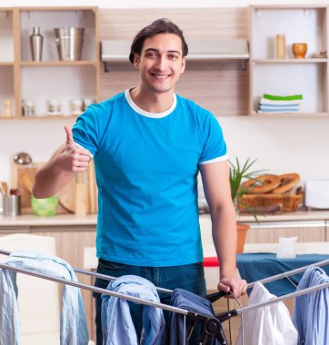 Genç adam evde ütü yapıyor.