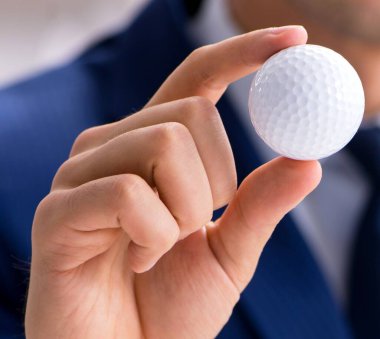 Ofiste çalışan golf topu ile genç işadamı