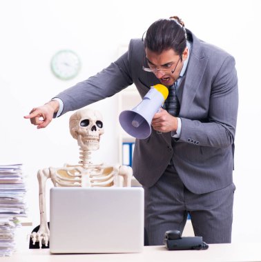 Ofisteki genç çalışan ve iskelet.