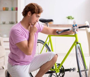 Kırık bisikletini tamir eden adam.