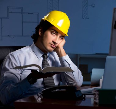 Genç inşaat mimarı geceleri proje üzerinde çalışıyor.