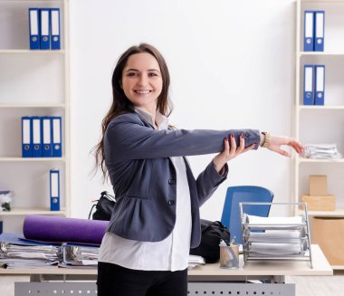 The female employee doing sport exercises in the office