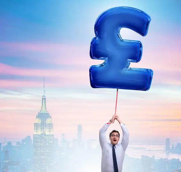 The businessman flying on british pound sign inflatable balloon
