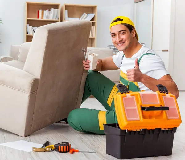 The worker repairing furniture at home