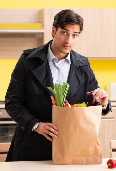 台所に野菜を持つ若いハンサムな男 — ストック写真