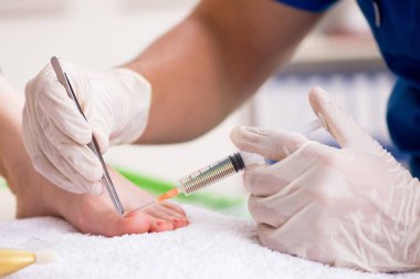 İşlem sırasında ayakları tedavi eden pediatrist