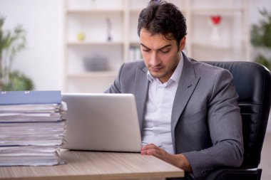 Genç işadamı ve ofiste çok fazla iş var.