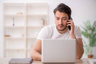 Genç çalışan işyerinde oturuyor.