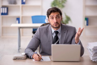 Genç işadamı ve ofiste çok fazla iş var.