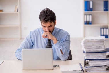 Genç bir çalışan ve ofiste çok fazla iş var.