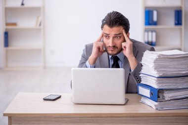 Genç bir çalışan ve ofiste çok fazla iş var.