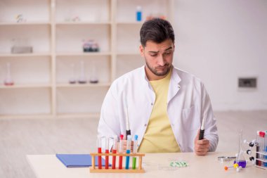 Young chemist sitting at the lab