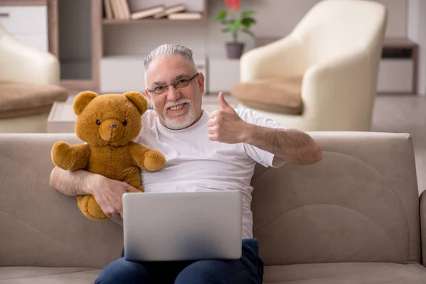 Old man with toy bear at the home