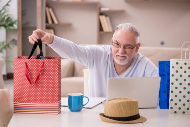 Old man with many bags in Christmas concept indoors