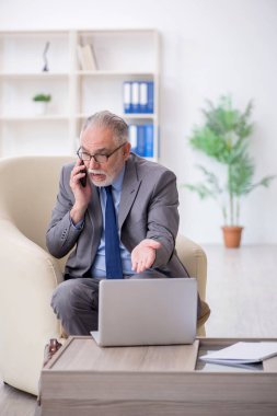 Ofiste telefonla konuşan eski bir çalışan.