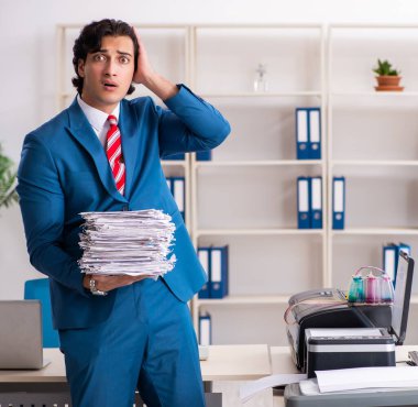 Kopyalama makinesinde fotokopi çeken genç çalışan.