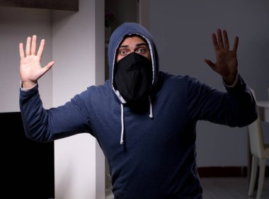 Hırsız, apartmandan televizyon çalıyor.