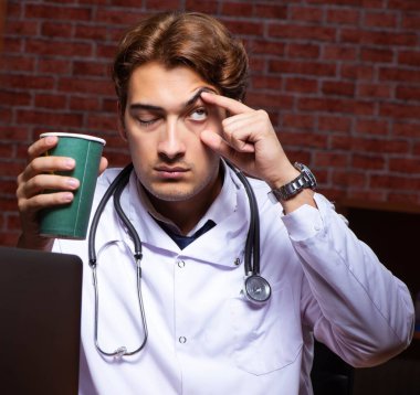 Genç, yakışıklı doktor gece hastanede çalışıyor.