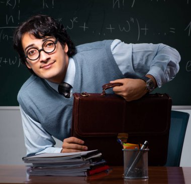 Tahtanın önündeki genç matematik öğretmeni.