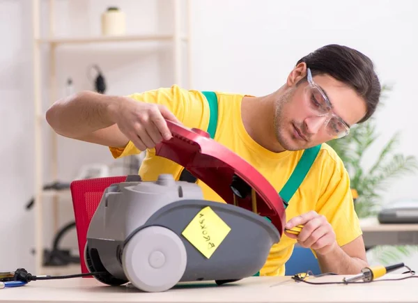 The man repairman repairing vacuum cleaner