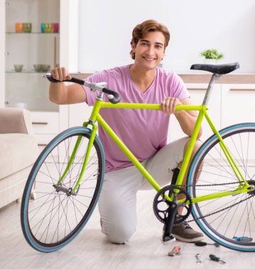 Kırık bisikletini tamir eden adam.