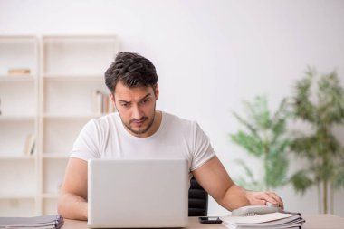 Genç çalışan işyerinde oturuyor.