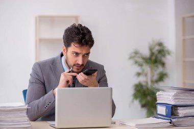 Genç bir çalışan ve ofiste çok fazla iş var.