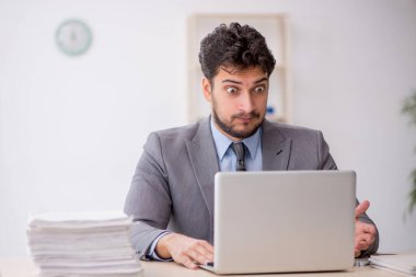 Genç bir çalışan ve ofiste çok fazla iş var.