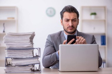 Genç bir çalışan ve ofiste çok fazla iş var.