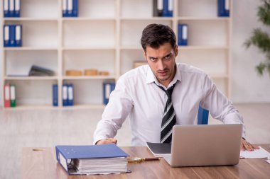 Genç işadamı işyerinde oturuyor.