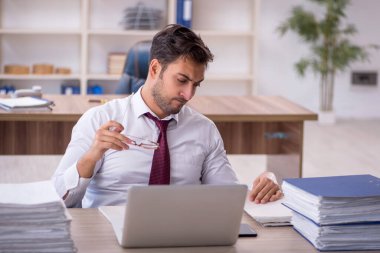 Genç işadamı işyerinde oturuyor.