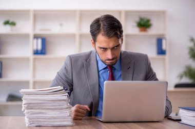 Genç işadamı işyerinde oturuyor.