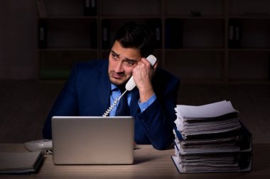 Young employee working late at workplace