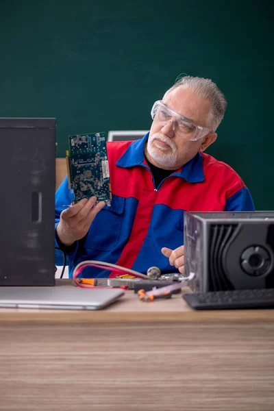 Sınıfta Bilgisayar Tamir Eden Yaşlı Bir Erkek Tamirci — Stok fotoğraf
