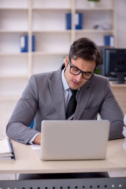 Genç işadamı ve ofiste çok fazla iş var.