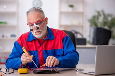 Laboratuvarda eski bir tamirci bilgisayar tamir ediyordu.