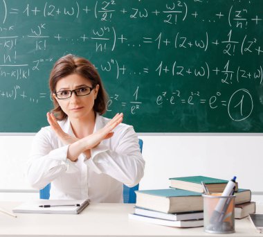 Karatahtanın önündeki kadın matematik öğretmeni.