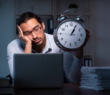 Ofiste gece çalışan genç bir çalışan.