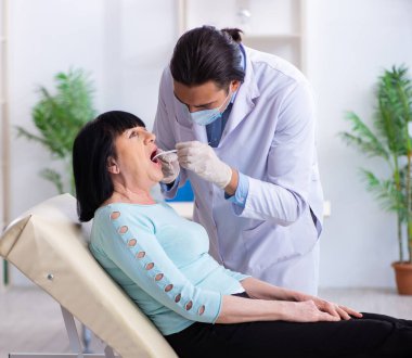 Yaşlı kadın genç dişçiyi ziyaret ediyor.