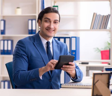 Ofisteki genç ve yakışıklı çalışan.